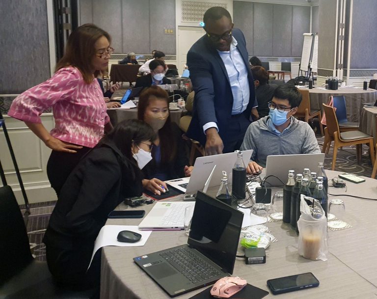 Photo of Dr Chris Nnanatu helping participants in the Workshop on Modelling Population Estimates to Support Census Processes in Thailand