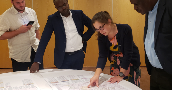 Tom Abbott and Heather Chamberlain with census managers at the Zambia National Statistics Agency. Includes microplanning maps that incorporate GRID3 modelled population estimates. Lusaka, Zambia.