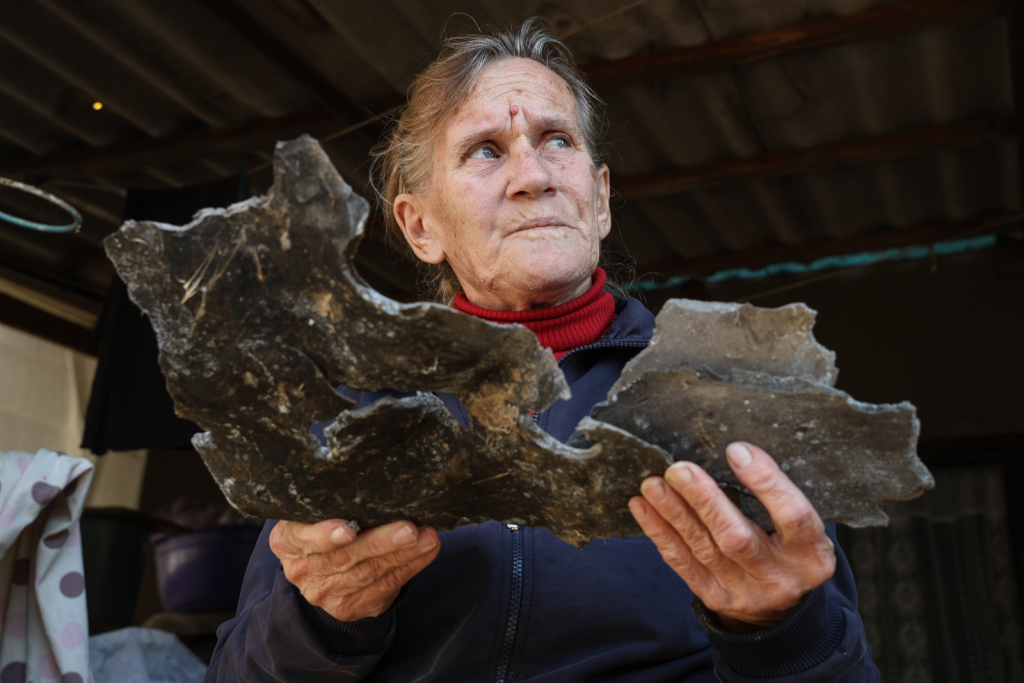 Photo of woman holding large piece of shrapnel