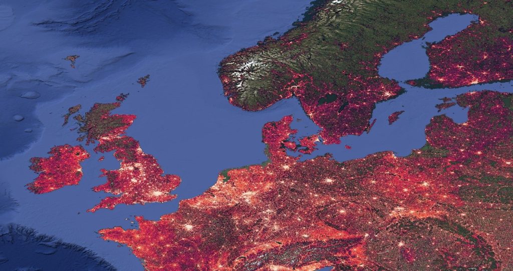 An image of WorldPop Global 2 population estimates overlaid on satellite imagery for Northern Europe showing high population numbers in white and lower numbers in red. 2025