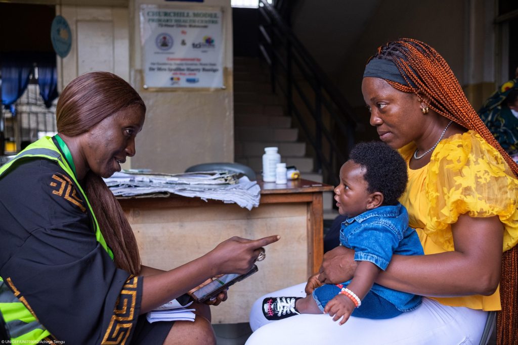 Photo of an Adhoc Registrar, supporting a mother during a digital birth registration drive in Port Harcourt, Nigeria, part of a nationwide effort to ensure every child has a legal identity