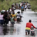 Photo of people wading through flooded road in Nigeria, 2022