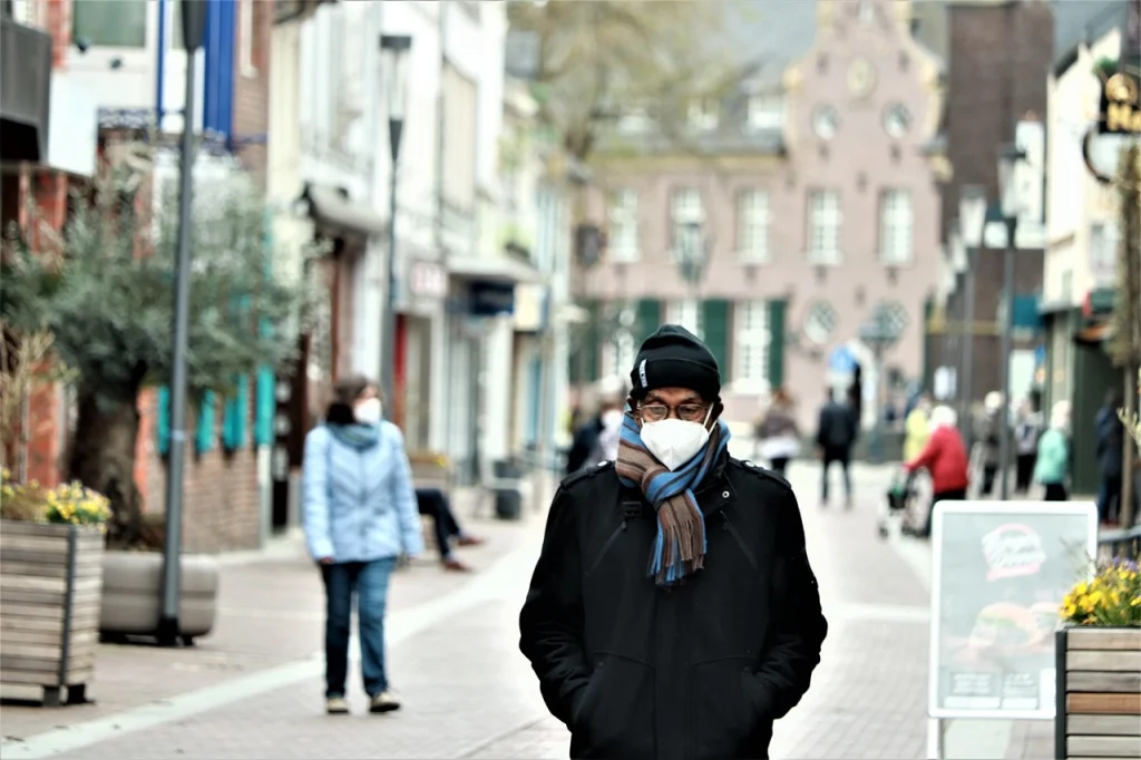 Photo of man wearing mask in street.