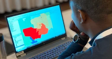 Photo of man looking at map application on a computer screen