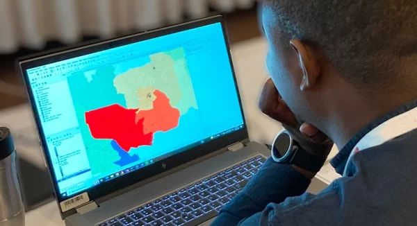 Photo of man looking at map application on a computer screen