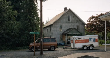 Photo of u-haul trailer parked outside a rural cottage