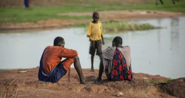 Photo of young men sitting close to a fishing river in South Sudan