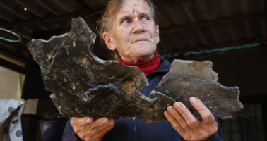 Photo of woman holding large piece of shrapnel