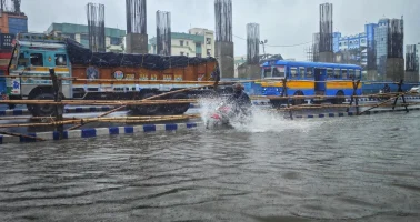 Photo of a truck a, a bus and a motorcycle on a city street during a flood.