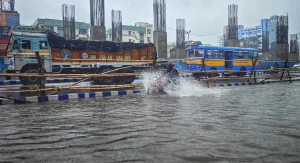 Photo of a truck a, a bus and a motorcycle on a city street during a flood.